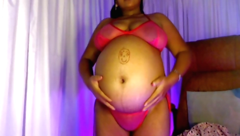 Pregnant girl in a black dress showing a beautiful bikini body