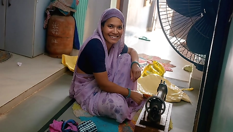 Indian lady sews her clothes with a sewing machine